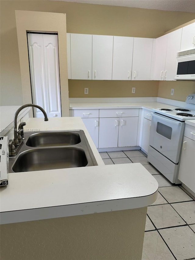 kitchen featuring white cabinets, sink, light tile patterned floors, and white appliances