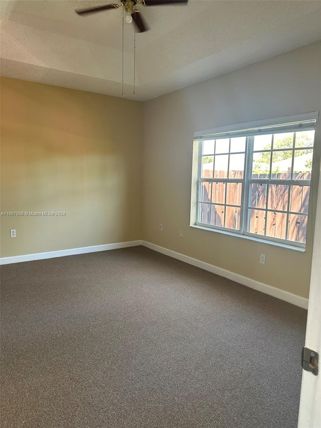 unfurnished room with a textured ceiling, carpet flooring, and ceiling fan