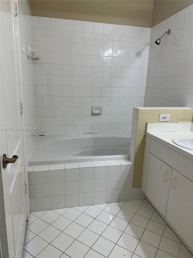 bathroom featuring tiled shower / bath, vanity, and tile patterned flooring