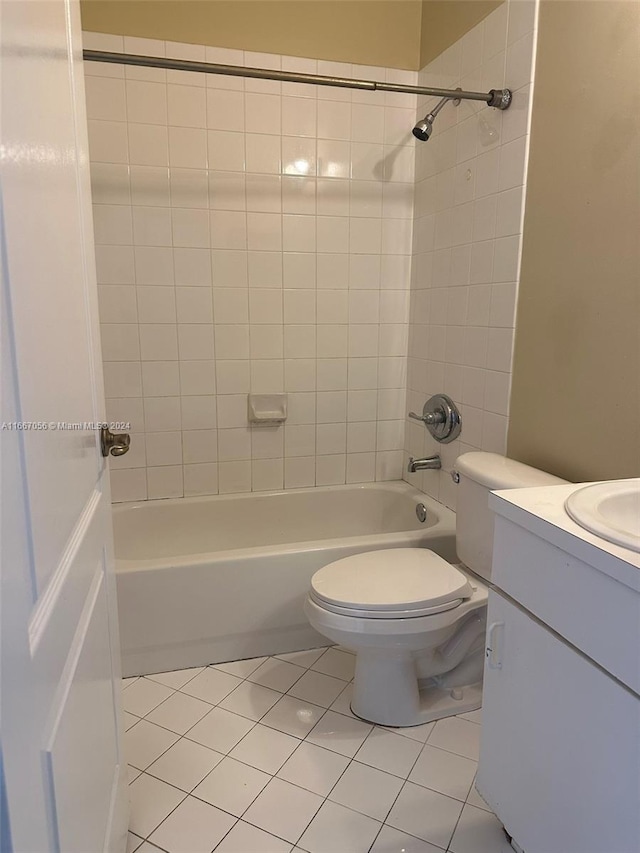 full bathroom with toilet, tiled shower / bath, vanity, and tile patterned floors