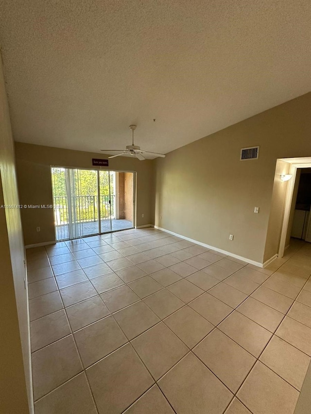 empty room with a textured ceiling, light tile patterned floors, and ceiling fan