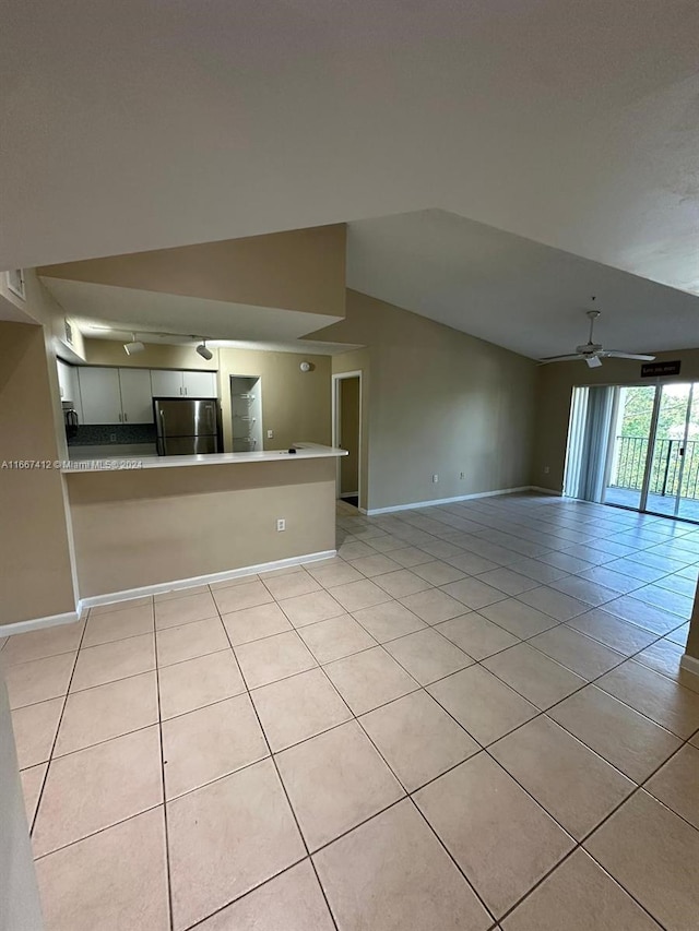 unfurnished living room featuring lofted ceiling, ceiling fan, and light tile patterned flooring