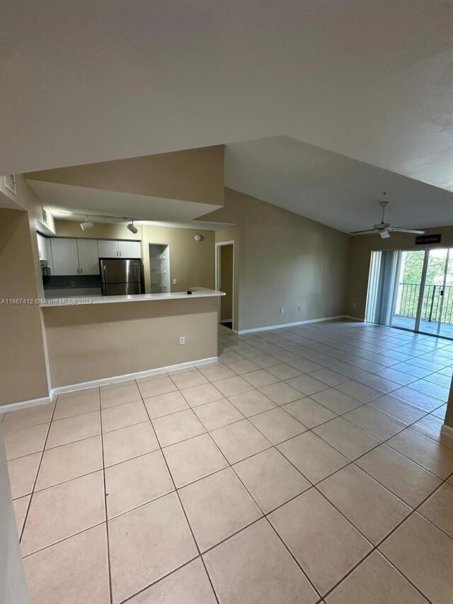 4848 N State Road 7 Unit 4305, Coconut Creek, FL 33073 - unfurnished living room featuring ceiling fan, light tile patterned flooring, and vaulted ceiling