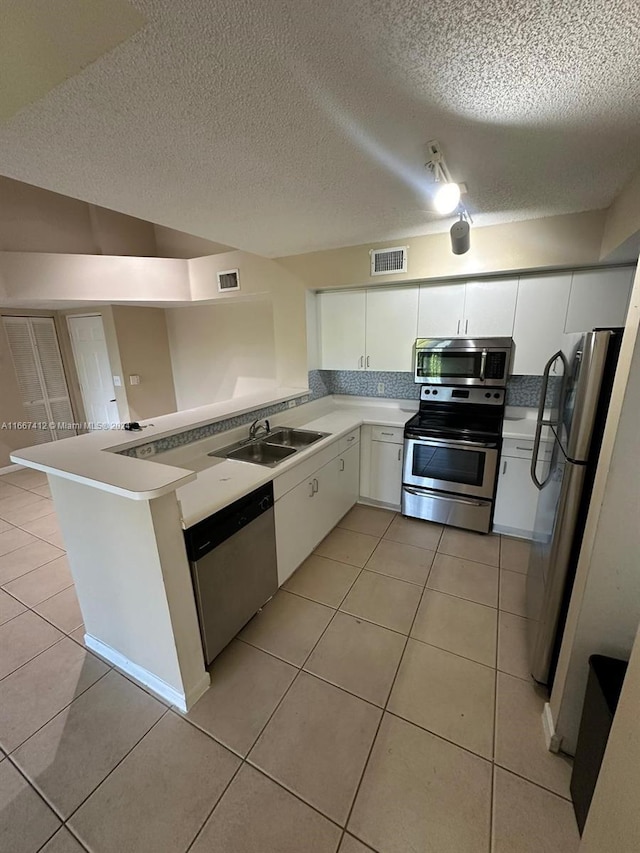 kitchen with kitchen peninsula, sink, stainless steel appliances, and white cabinets