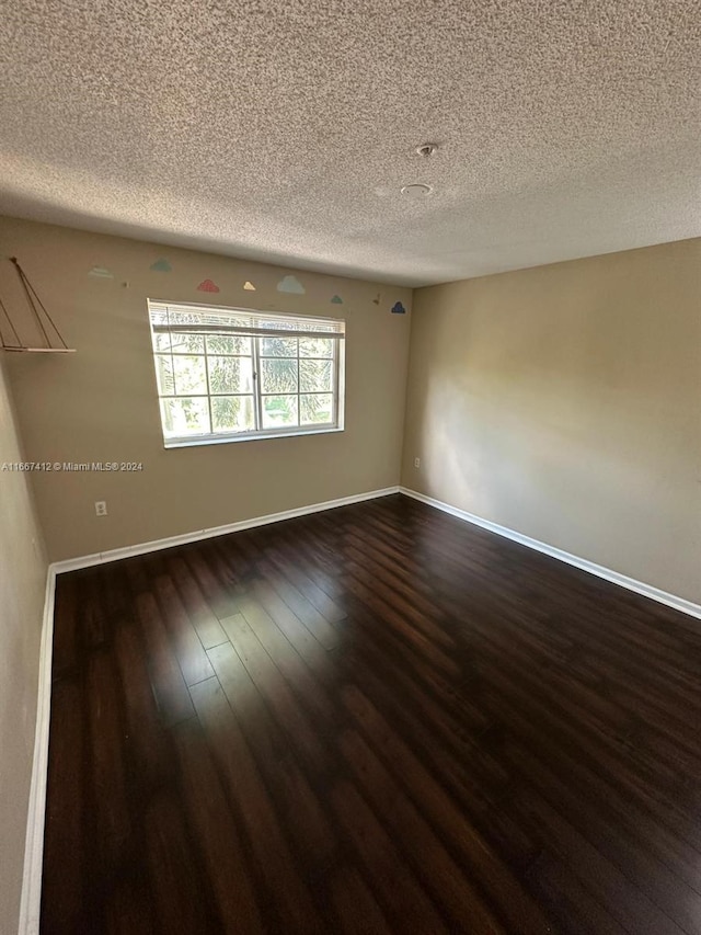 4848 N State Road 7 Unit 4305, Coconut Creek, FL 33073 - empty room with dark wood-style flooring and a textured ceiling