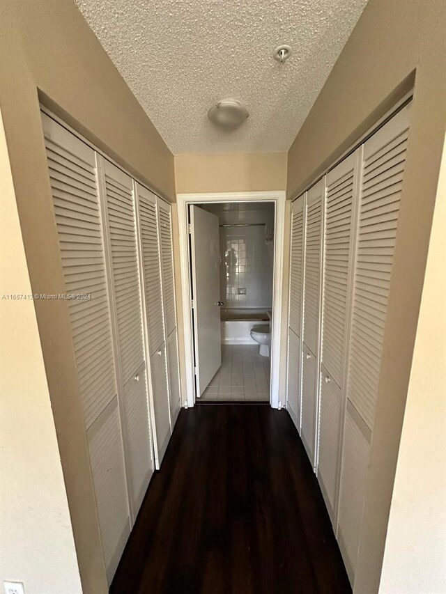4848 N State Road 7 Unit 4305, Coconut Creek, FL 33073 - corridor featuring a textured ceiling and wood finished floors
