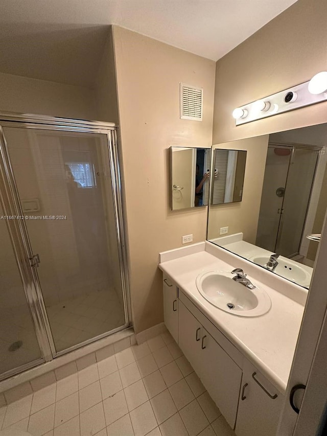 bathroom featuring walk in shower, vanity, and tile patterned floors