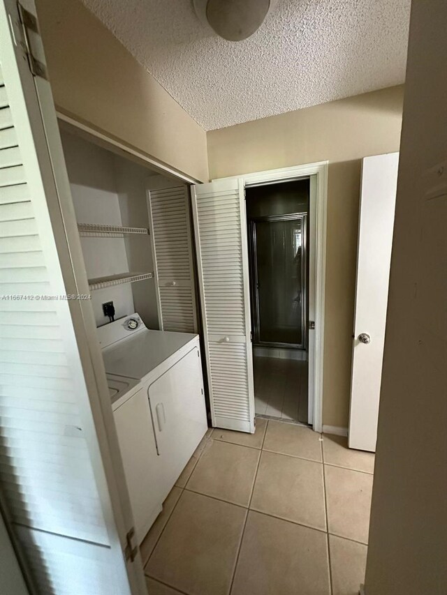 4848 N State Road 7 Unit 4305, Coconut Creek, FL 33073 - laundry room with a textured ceiling, light tile patterned flooring, and electric dryer hookup