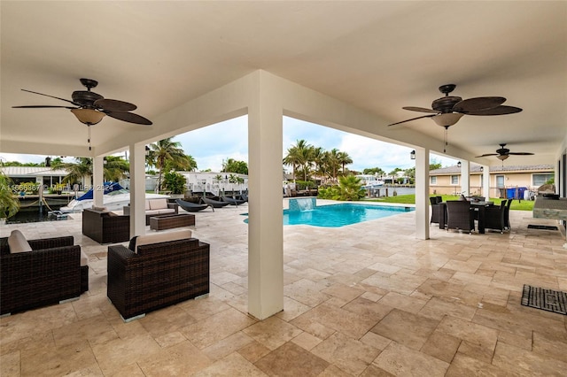 view of pool with an outdoor living space, ceiling fan, and a patio area