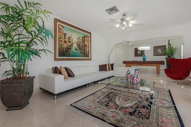 living room featuring ceiling fan with notable chandelier