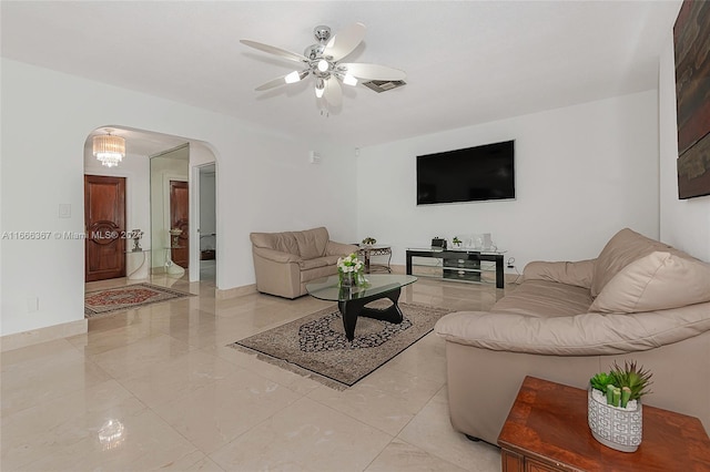 living room with ceiling fan with notable chandelier