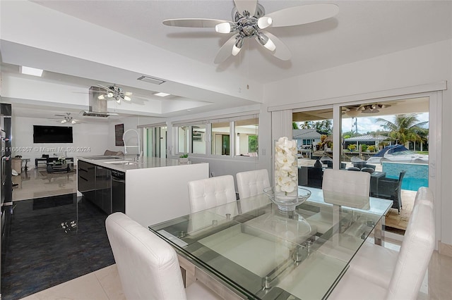 tiled dining room with ceiling fan, plenty of natural light, and sink