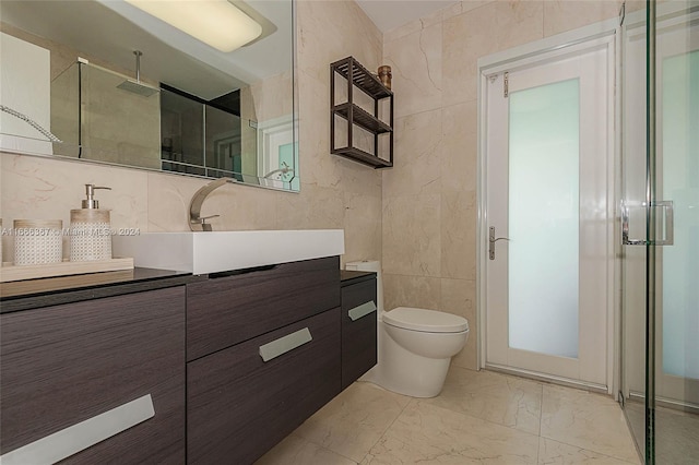 bathroom with vanity, tile walls, toilet, and a shower with door