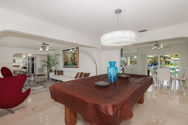 recreation room with ceiling fan with notable chandelier