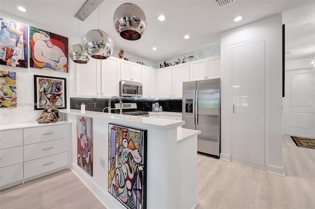 kitchen featuring white cabinetry, hanging light fixtures, stainless steel appliances, and kitchen peninsula