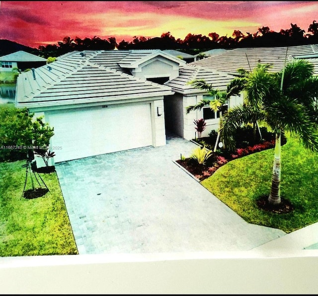 view of front facade with a garage and a lawn