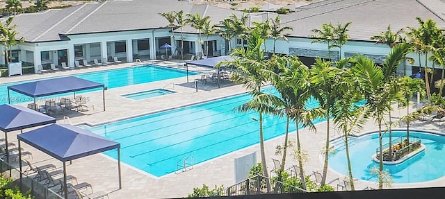 view of swimming pool with a hot tub and a patio area