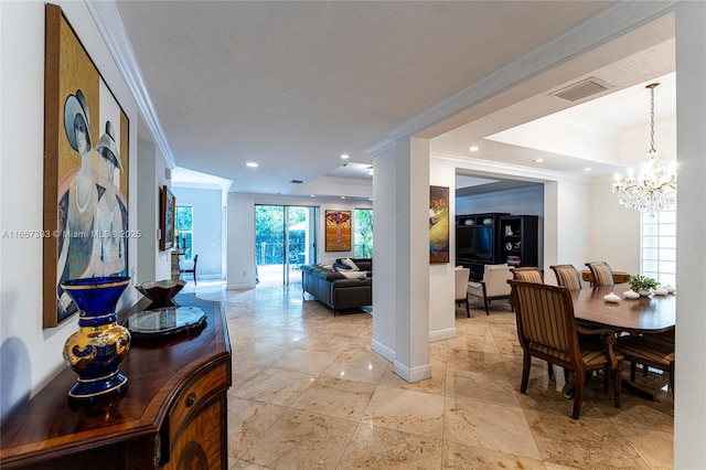 hall featuring a notable chandelier, ornamental molding, and a tray ceiling