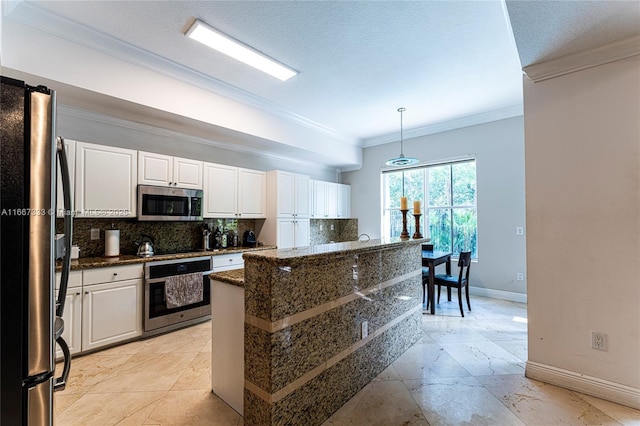 kitchen featuring backsplash, stainless steel appliances, a kitchen island, pendant lighting, and white cabinetry