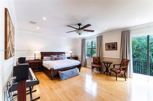 bedroom featuring ceiling fan, crown molding, a textured ceiling, and light wood-type flooring