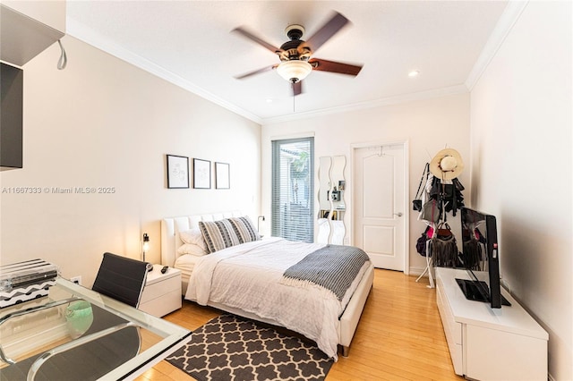 bedroom featuring ceiling fan, light wood-type flooring, and crown molding