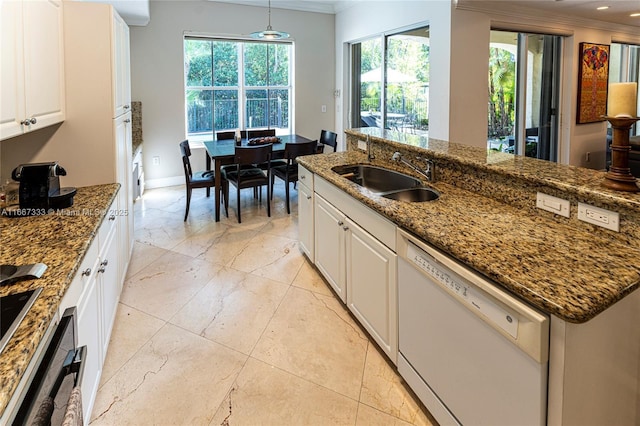 kitchen with pendant lighting, dark stone counters, white dishwasher, sink, and white cabinetry