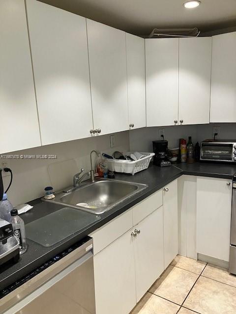 kitchen with white cabinets, appliances with stainless steel finishes, and light tile patterned flooring