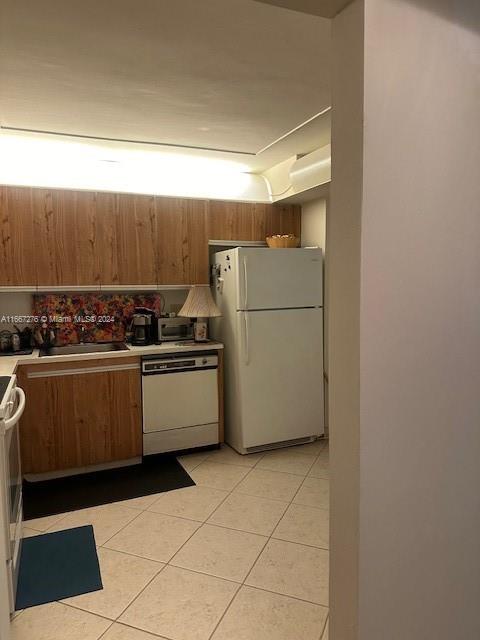 kitchen featuring white appliances and light tile patterned floors