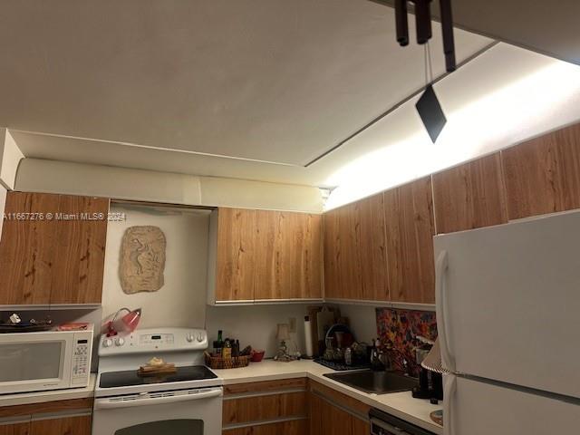 kitchen featuring white appliances and sink