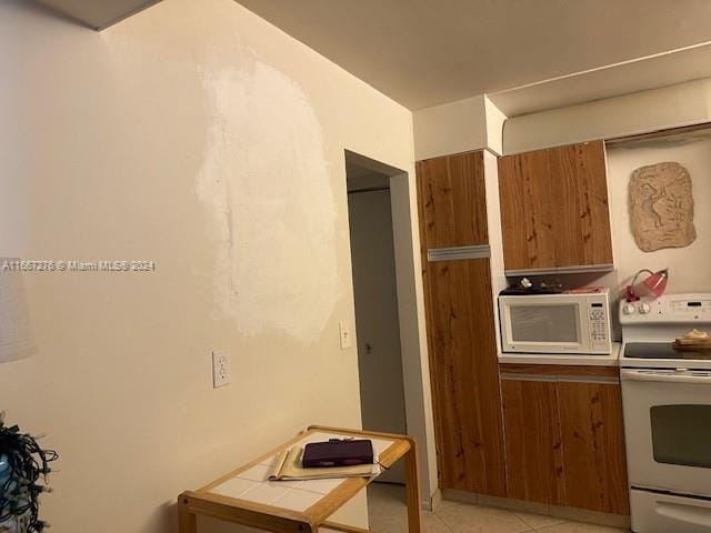 kitchen with white appliances, tile countertops, and light tile patterned floors