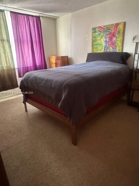 bedroom featuring a textured ceiling and carpet flooring