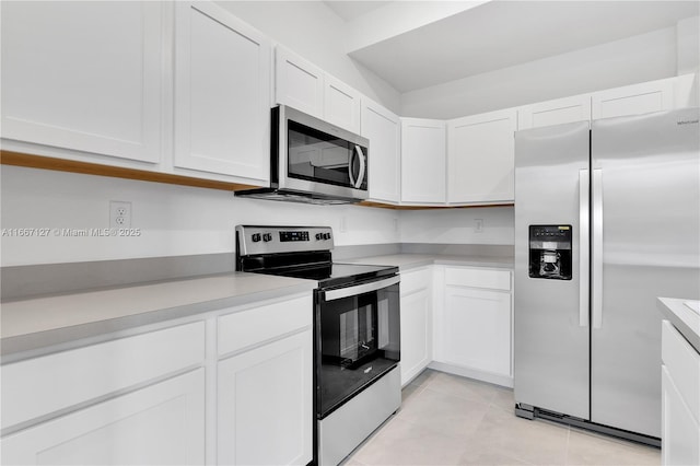 kitchen with white cabinets, stainless steel appliances, and light tile patterned floors