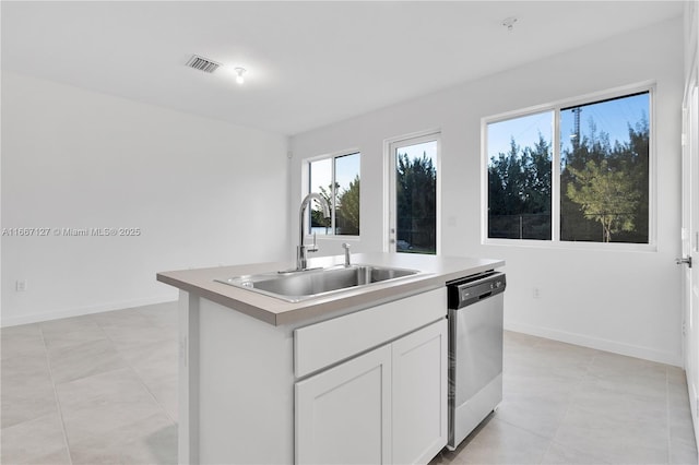 kitchen featuring dishwasher, white cabinets, a center island with sink, sink, and light tile patterned floors