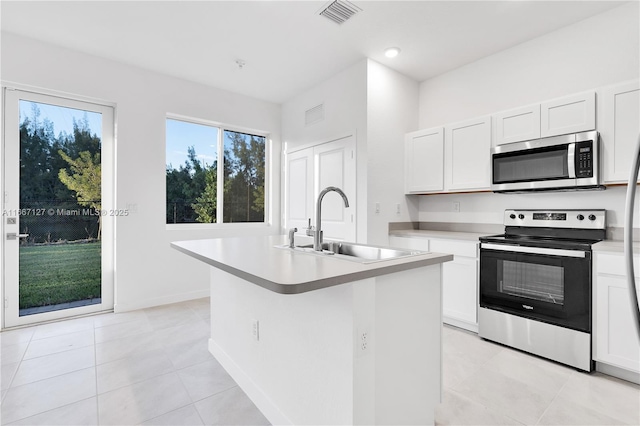 kitchen featuring white cabinets, an island with sink, and appliances with stainless steel finishes