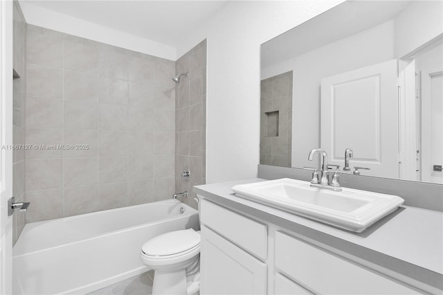 full bathroom featuring tile patterned flooring, vanity, tiled shower / bath combo, and toilet