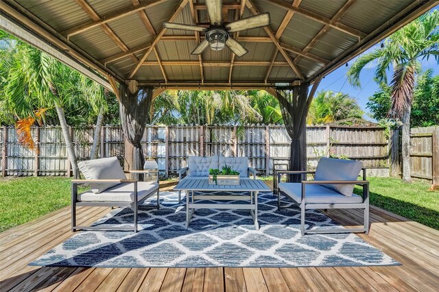 wooden terrace featuring a gazebo, ceiling fan, and an outdoor hangout area