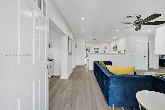 living room with ceiling fan and light wood-type flooring