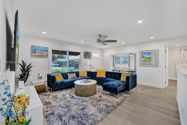 living room featuring light hardwood / wood-style flooring and ceiling fan