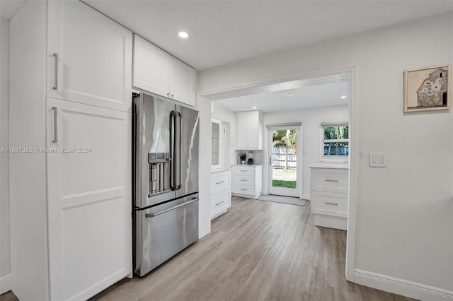 kitchen with white cabinets, light hardwood / wood-style floors, and stainless steel fridge with ice dispenser