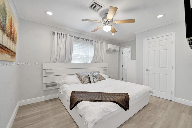 bedroom with ceiling fan, light wood-type flooring, ornamental molding, and a wall mounted AC