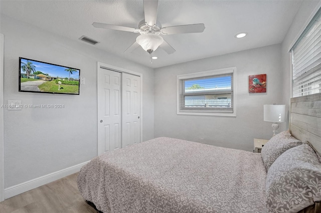 bedroom with ceiling fan, a closet, and light hardwood / wood-style floors