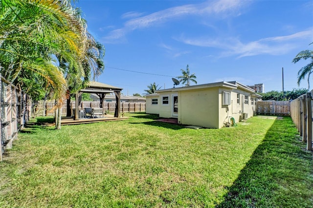 view of yard with a gazebo, a wooden deck, and central AC