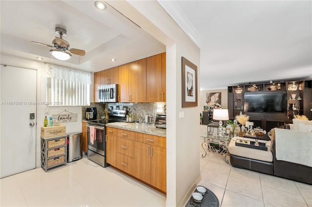 kitchen featuring decorative backsplash, ceiling fan, light tile patterned flooring, light stone counters, and stainless steel appliances