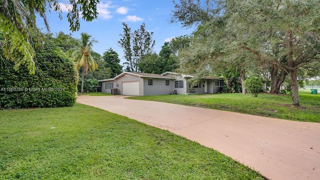 ranch-style house featuring a garage, a front lawn, and central AC