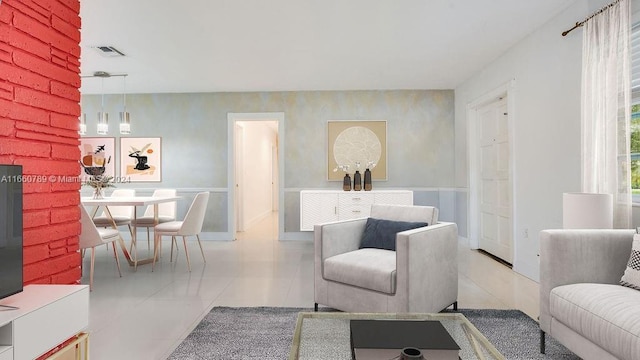 living room with tile patterned floors, visible vents, and wainscoting