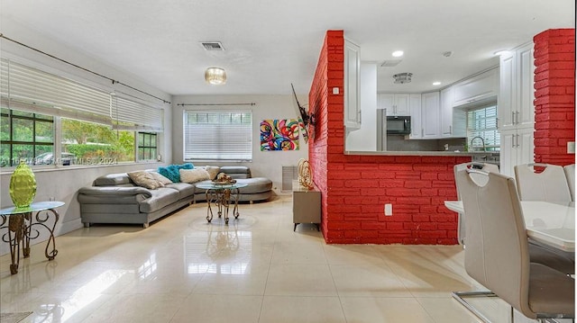 living room featuring light tile patterned floors and visible vents
