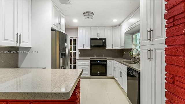 kitchen with white cabinets, a sink, and black appliances