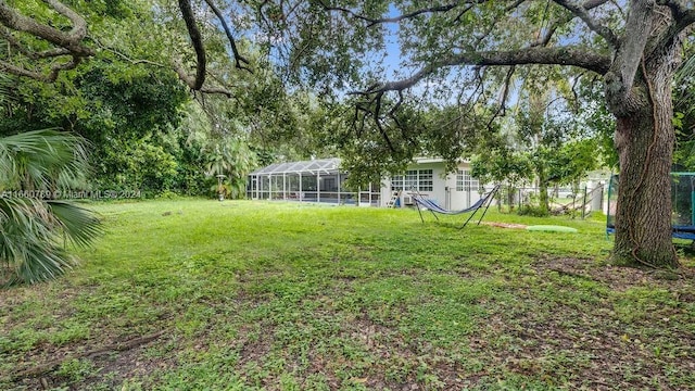 view of yard with fence and glass enclosure