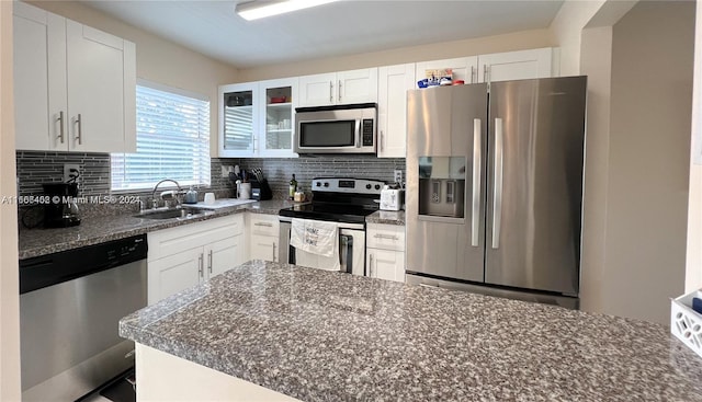 kitchen featuring decorative backsplash, stainless steel appliances, white cabinets, and sink