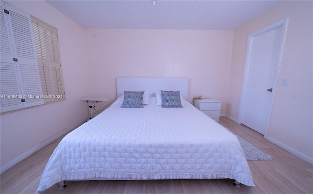 bedroom with light hardwood / wood-style flooring and a closet